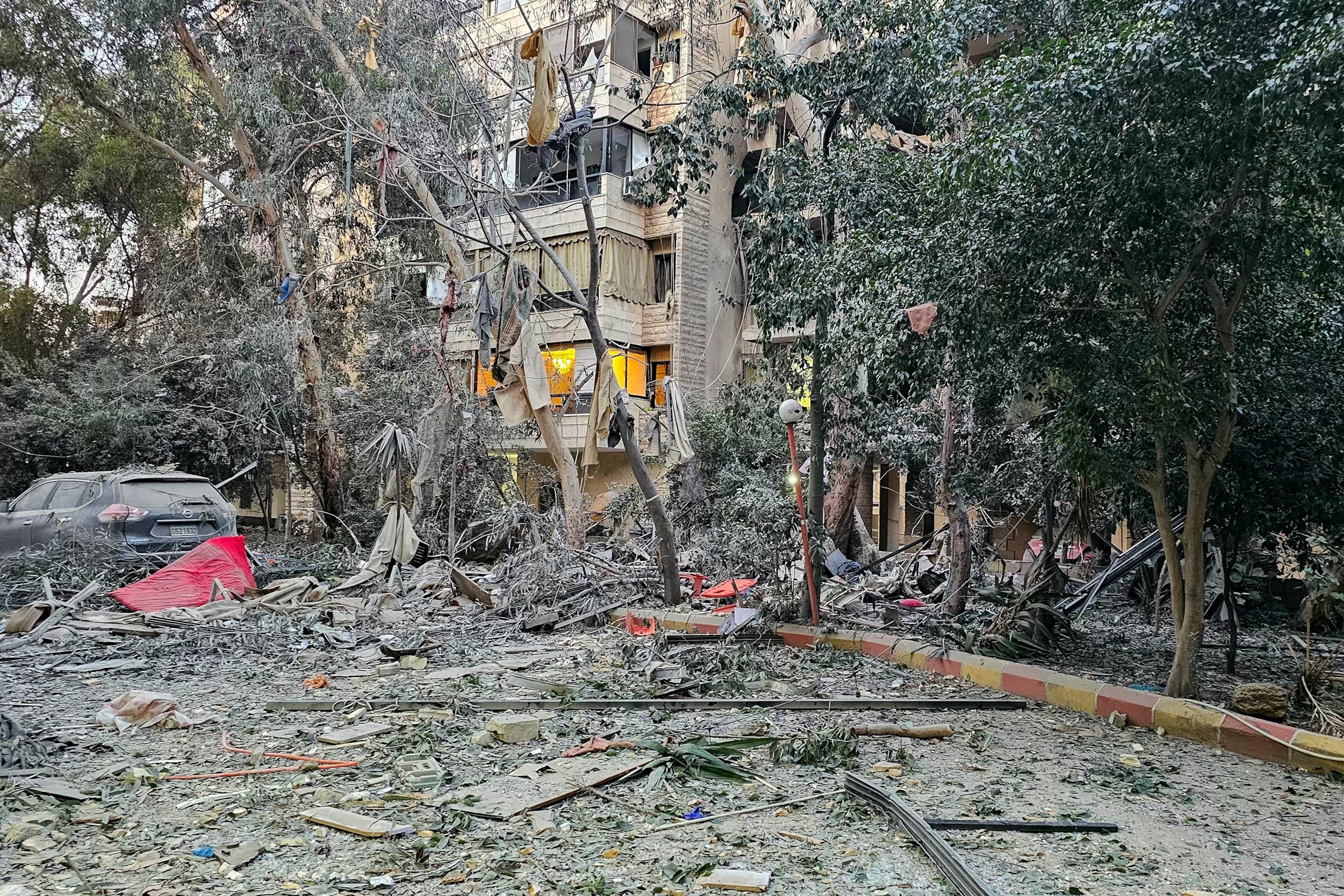 PHOTO: Debris is seen around a building damaged after an Israeli airstrike in Beirut's southern suburb neighborhood of Haret Hreik on March 2, 2026. 
