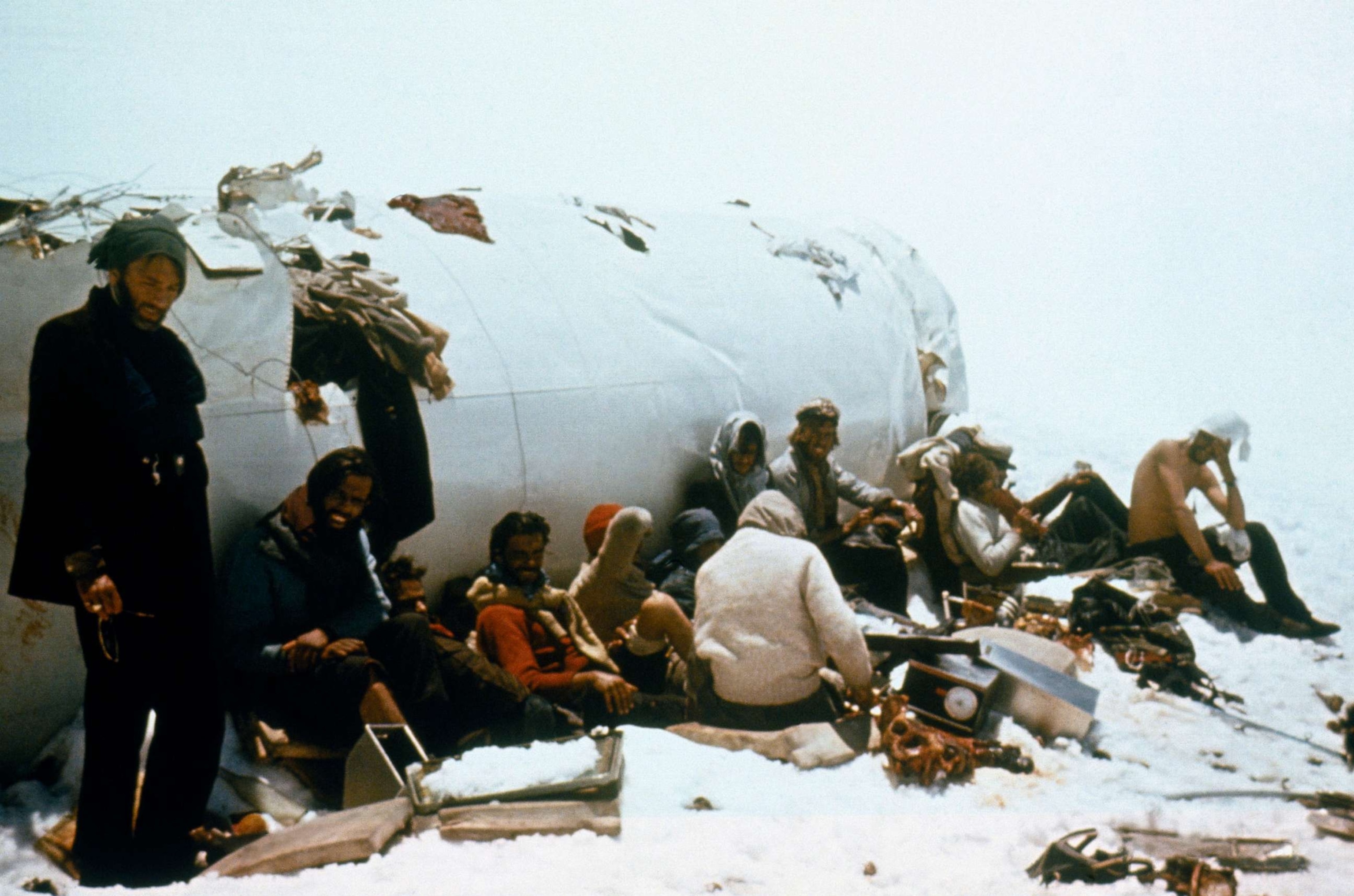 PHOTO: Survivors sitting outside the fuselage. According to Eduardo Strauch, they would speak to each other in low volumes to conserve energy.