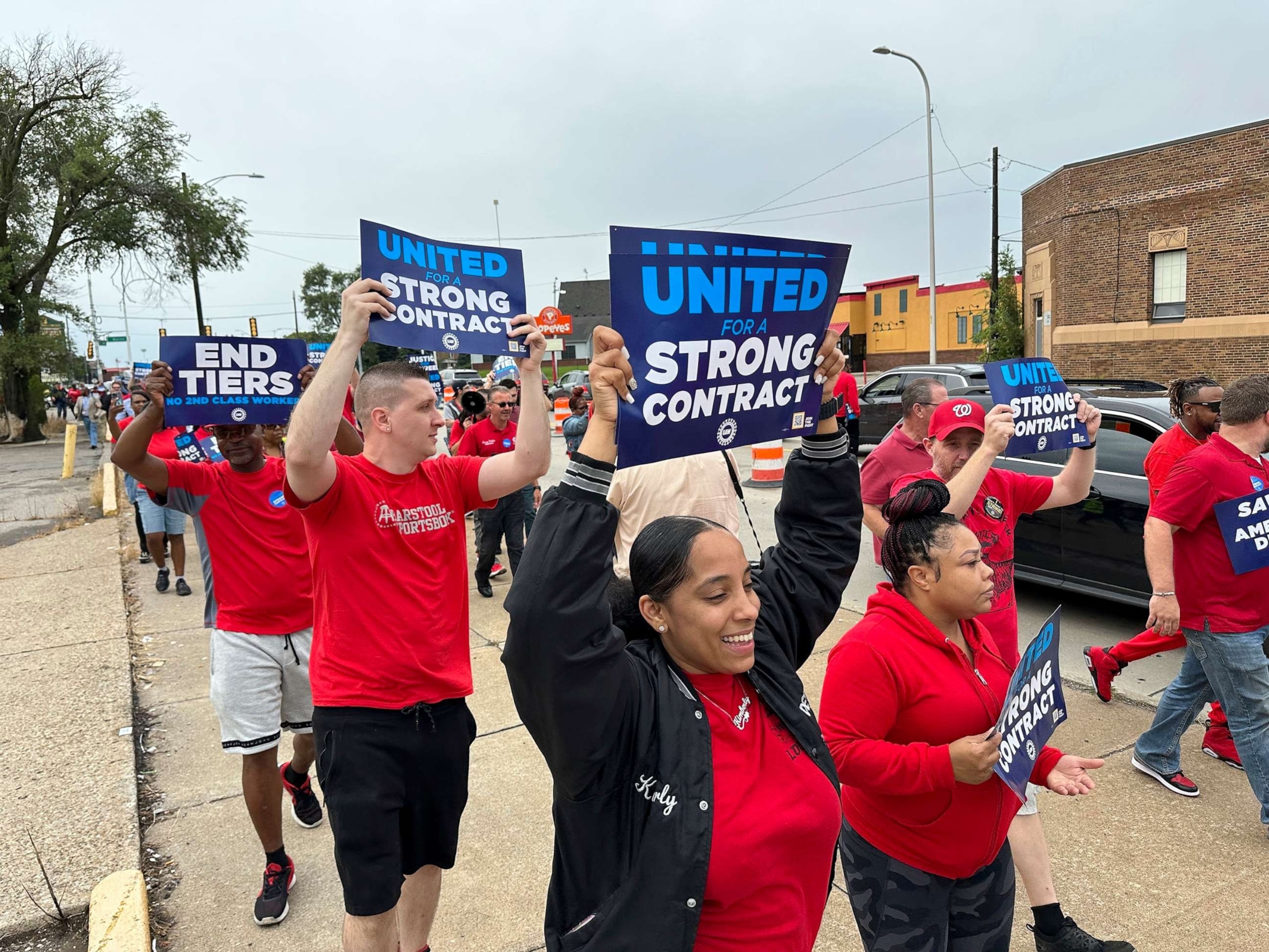 PHOTO: United Auto Workers members march while holding signs at a union rally held near a Stellantis factory on Aug. 23, 2023, in Detroit., Mich.