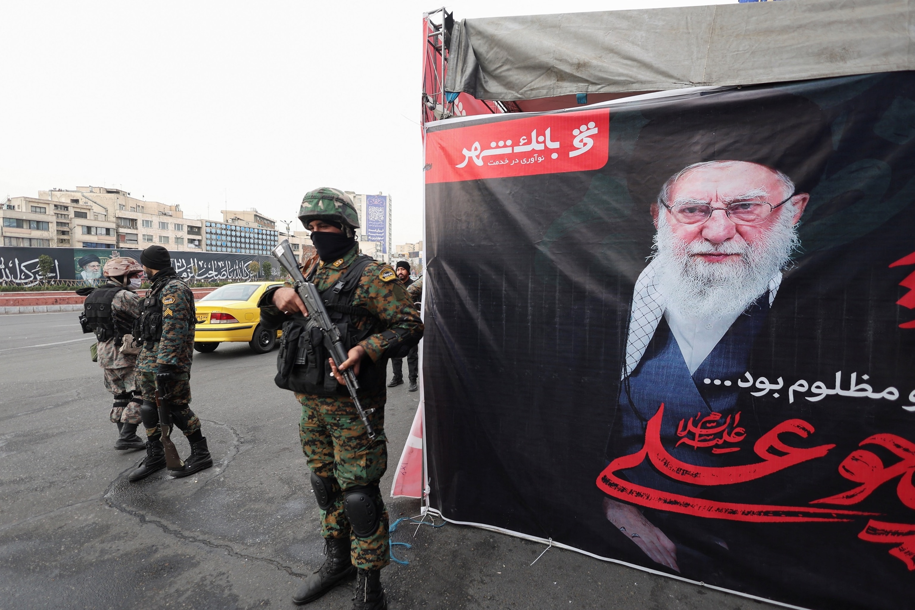 PHOTO: Members of the police stand guard on a street in the capital, next to a large banner featuring Iran's late Ali Khamenei, and other banners visible in the background, amid the U.S.-Israeli conflict with Iran, in Tehran, Iran, March 12, 2026.