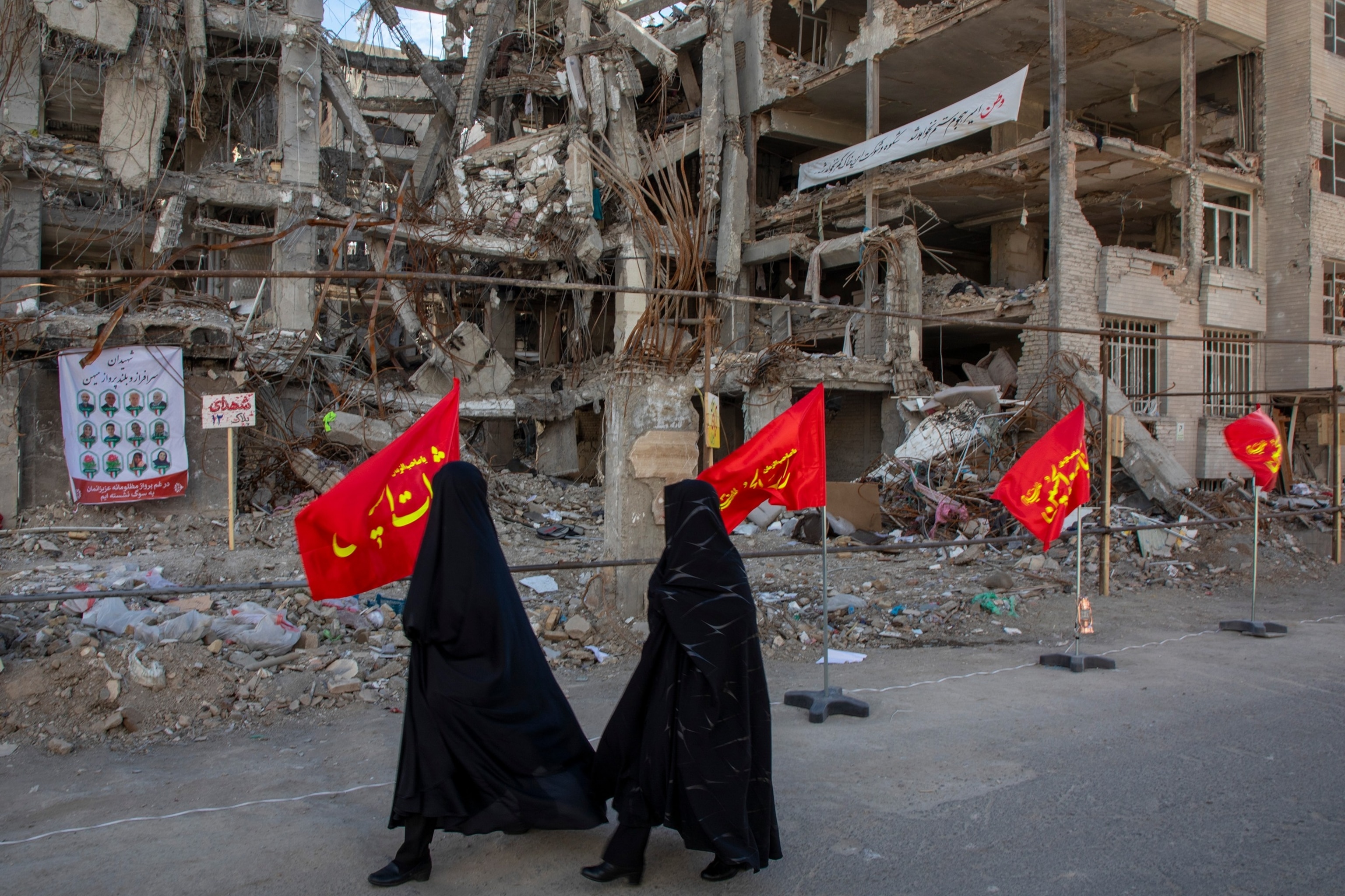 PHOTO: U.S. Women walk past buildings destroyed in a joint attack by Israel and the United States, April 6, 2026, in Tehran, Iran.