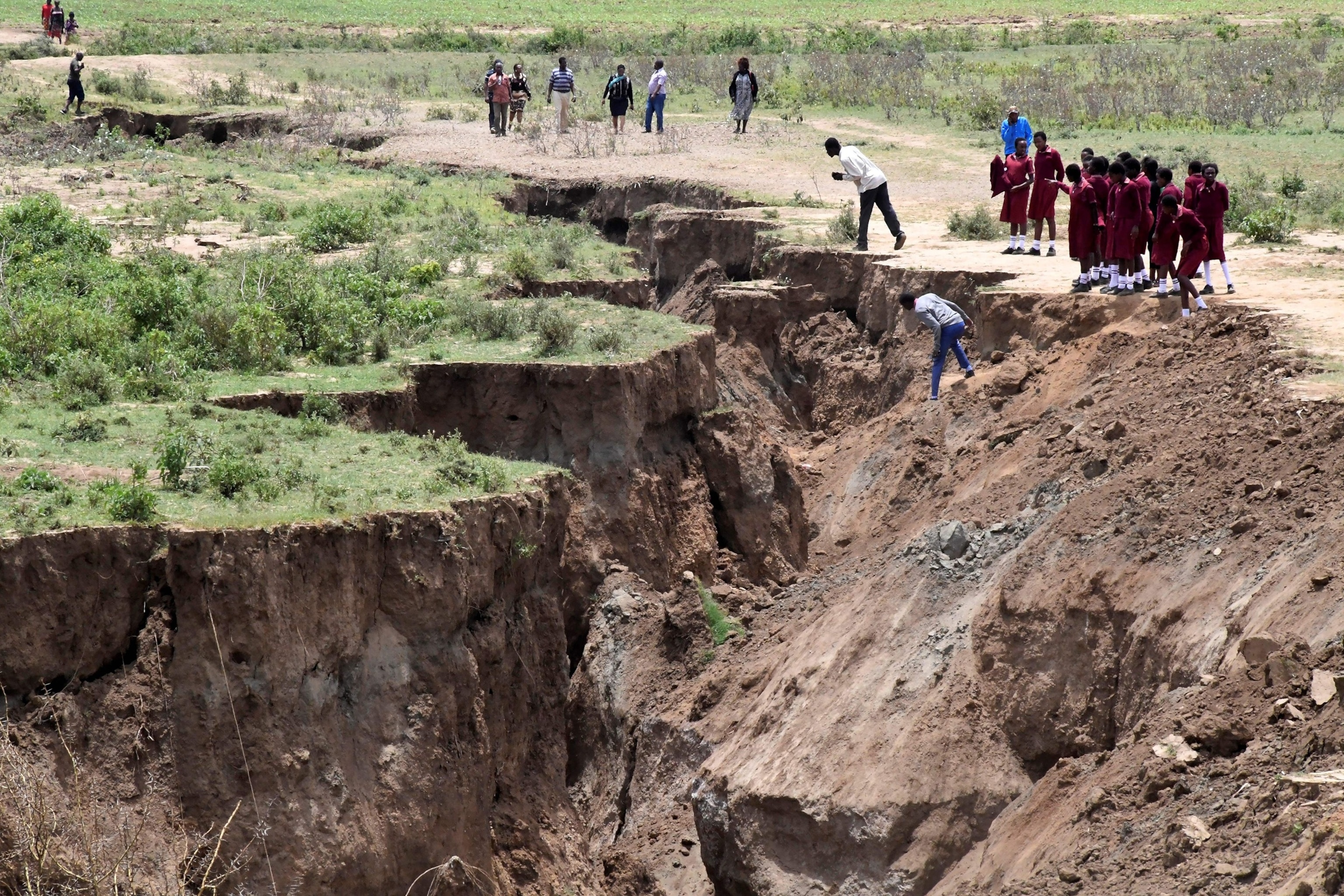 PHOTO: In this April 6, 2018, file photo, people and school children walk next to a deep chasm in the earth near the town of Mai-Mahiu, Nakuru County in the Rift Valley, some 54kms (33.5 miles) south-west of Nairobi.