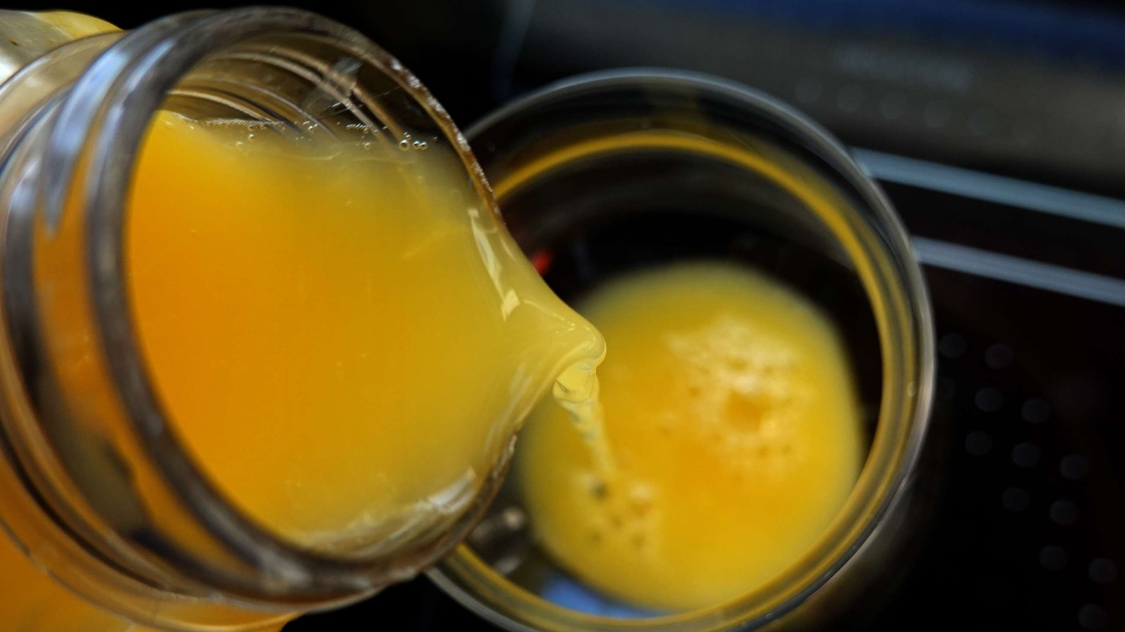 In this photo illustration, orange juice is poured into a glass.