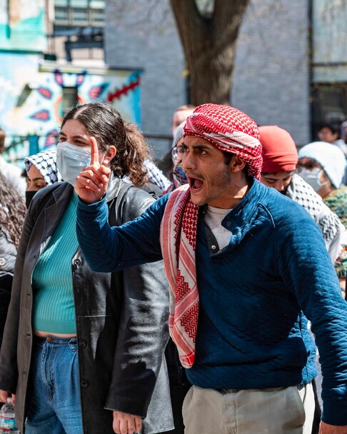 Pro-Palestinian protesters stand in front of a police barricade after police raided an encampment at Northeastern University, in Boston, on April 27, 2024. 