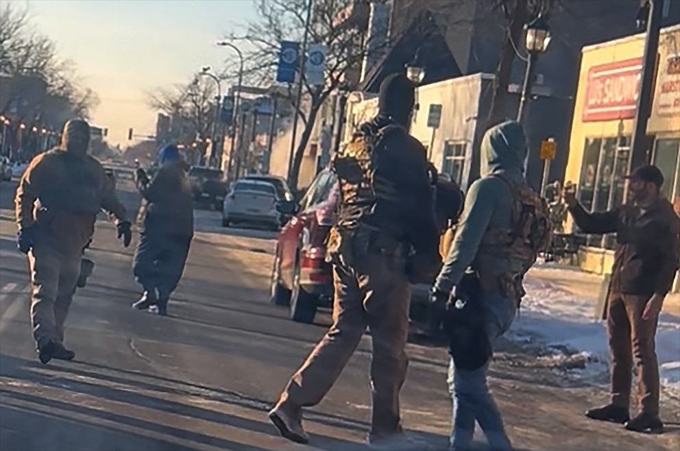 PHOTO: Pretti is seen lifting a phone towards the officers as they move a detainee into a nearby vehicle