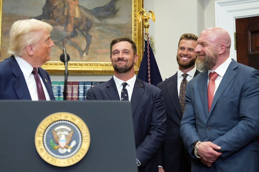 PHOTO: President Donald Trump speaks as wrestler Triple H, Kansas City Chiefs, Harrison Butker and golfer Bryson DeChambeau listen July 31, 2025, at the White House in Washington.