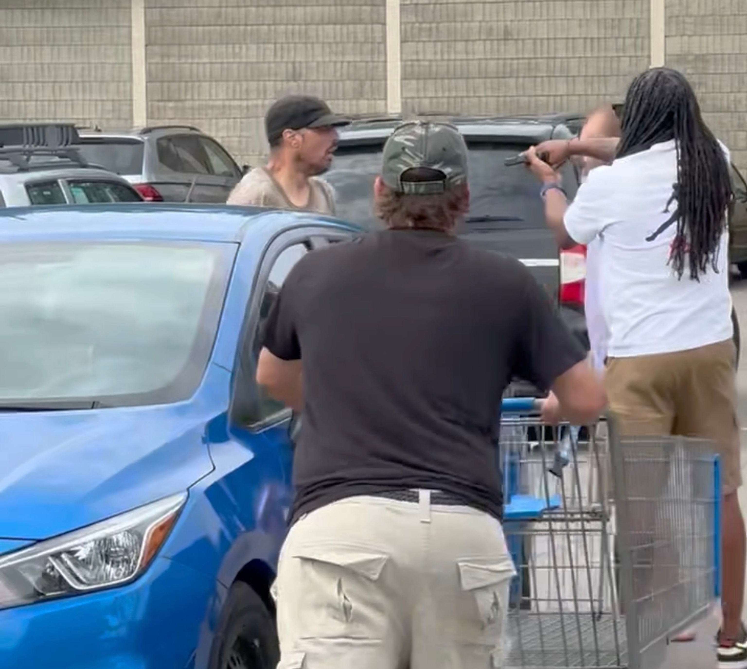 PHOTO: A bystander video shows suspect Bradford James Gille, 42, (to the left wearing a black cap) is confronted, July 26, 2025, by a group of citizens outside a Walmart in Traverse City, Michigan.