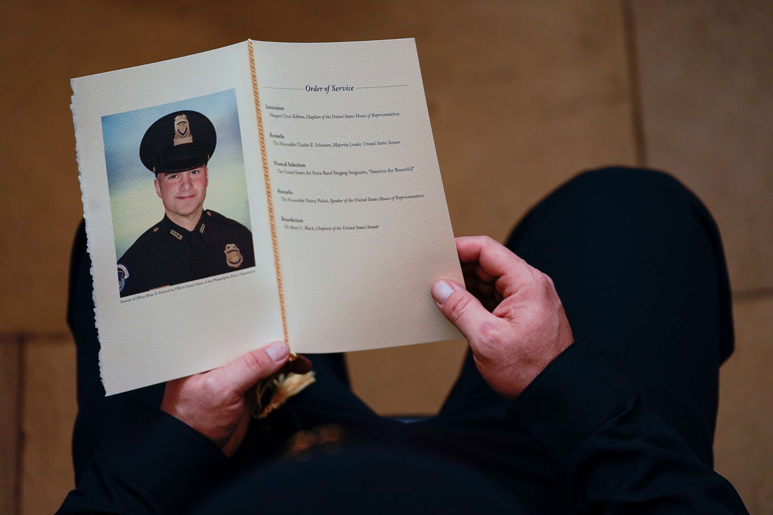 PHOTO: A U.S. Capitol Police Officer holds a program for the ceremony memorializing Police Officer Brian D. Sicknick, 42, as he lies in honor in the Rotunda of the Capitol, Feb. 3, 2021, in Washington.